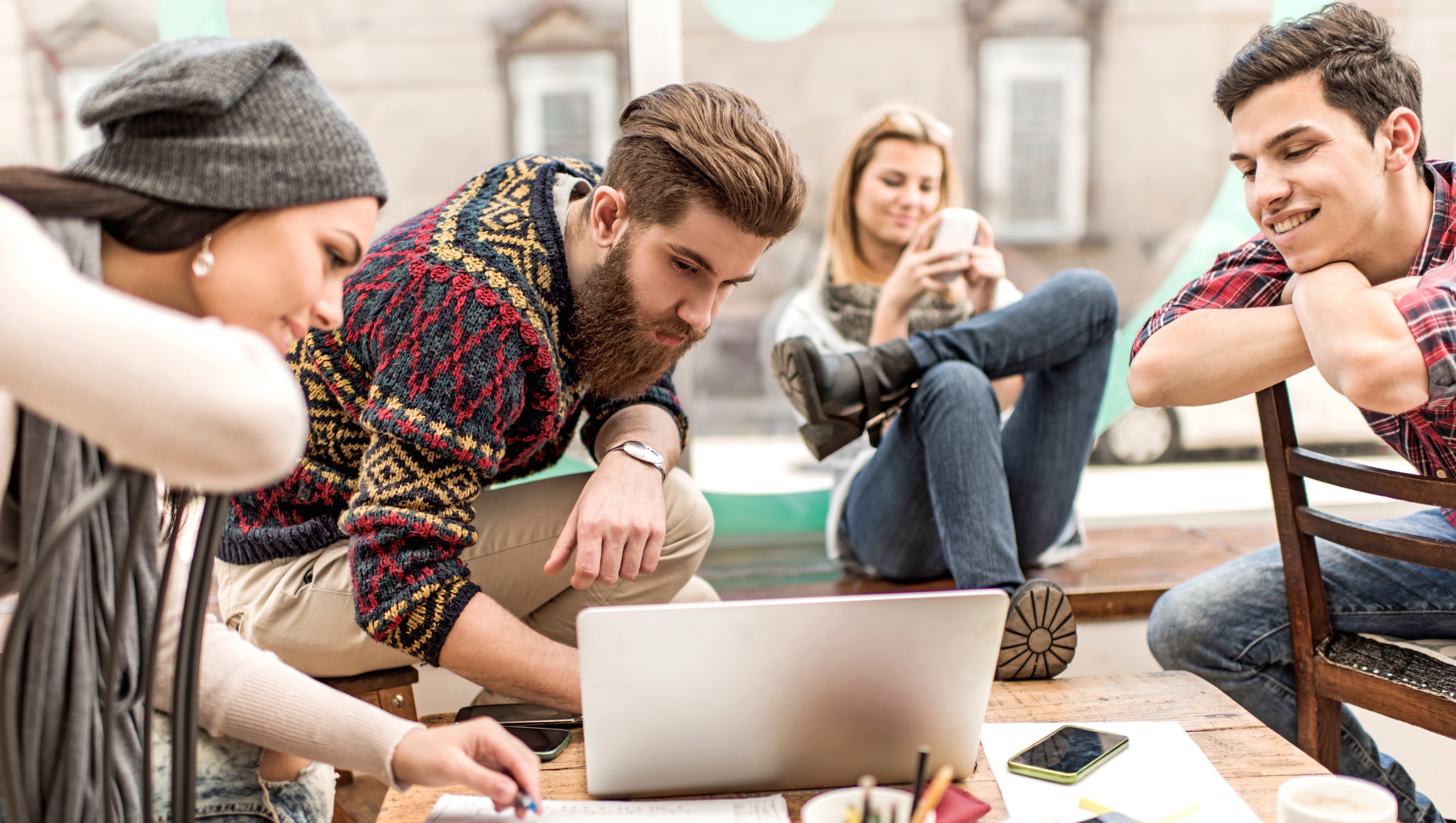 Group of young people using laptop.